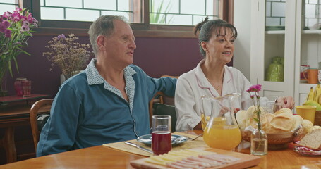Family eating breakfast in the morning. Daughter and parents talking at kitchen table
