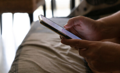 Fototapeta premium hands using a cell phone with a light on the screen