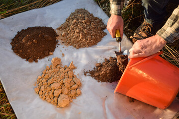 Male agronomy specialist preparing for soil analysis at field. Man farmer arranging soil samples,...