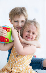  little boy and girl fighting over toy, siblings relationship, greed