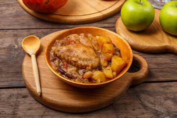 Chelnt with chicken in a wooden plate on the festive table for Rosh Hashanah.