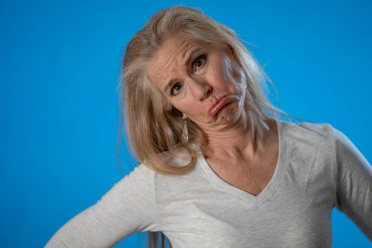 Closeup Portrait Of Sad, Funny, Mature Woman Isolated On Solid Blue Background.