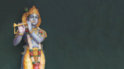 Lord Krishna with a flute on a dark background. Hindu God.