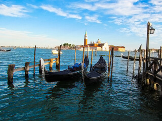 Fototapeta na wymiar Two gondolas in the sea on the background of San Giorgio Maggiore. Bright colorful photo