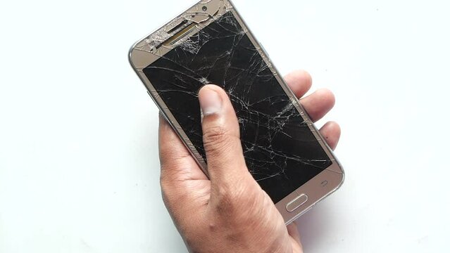 Close up of man hand holding broken smart phone on white background 