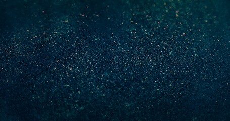 Defocused sparks. Glitter texture background. Firework reflection. Blur orange blue color shiny grain particles glare on dark futuristic abstract wallpaper.