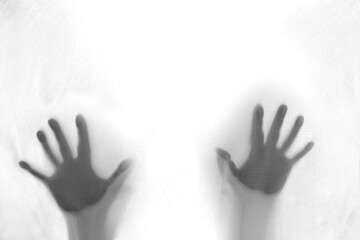 eerie blurry hands of people as if they have been trapped behind glass, dense fabric, wrap, ghost, spirit trying to reach out from afterlifeconcept of violence, nightmares, halloween horror