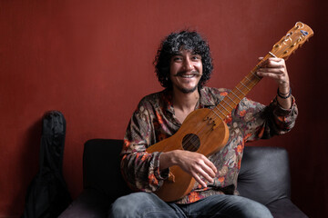 Portrait of a young Mexican musician posing with his jarana guitar