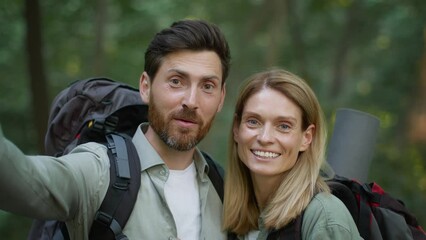 Camera pov portrait of happy man explorer with backpack recording video blog on phone, woman showing thumb up