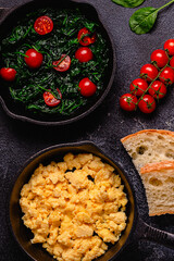 Cooked omelet and spinach with tomatoes in pans