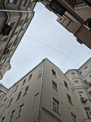 Enclosed courtyard (courtyard-well) with a low angle view. Sky surrounded by buildings and walls. Industrial frame. High quality photo