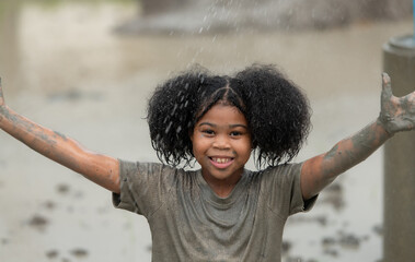 Little girls have fun playing in the mud in the community fields