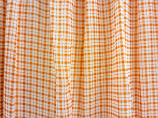 Close up of fabric folds of orange checkered pattern