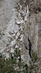 very high waterfall in the mountains between cliffs