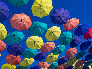 Fototapeta na wymiar Paraguas de colores colgados en las calles de Malpartida