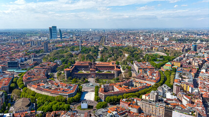 Aerial view of The Castello Sforzesco medieval fortification located in Milan, northern Italy. Flying around Sforzesco Castle citadel in Sempione Park ft. Milano urban skyline in Europe in 6K - obrazy, fototapety, plakaty