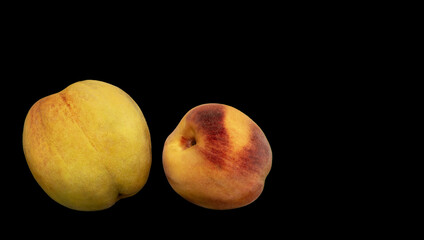 two ripe peaches on black background