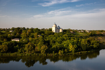 Fototapeta premium The old church above the river in the Ukrainian village on a summer evening.