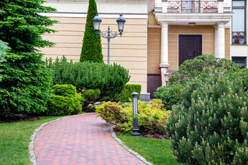 Backyard with bark mulched evergreens pine plants trees and bushes with needles and retro iron twin...