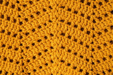 Yellow crochet texture with chevron stitch close up. Crochet fabric with zigzag pattern.