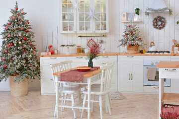 Interior of a light white ?hristmas kitchen with red decor elements in the Scandinavian style. Christmas decorations. Breakfast.Merry Christmas and Happy New Year!