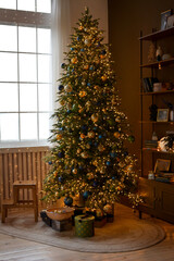 Christmas, New Year's interior. Beautifully luxury decorated Christmas tree, boxes with gifts on the background of the window and shelves with books.Christmas living room