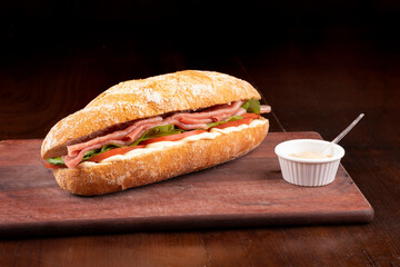 smoked carpaccio sandwich with arugula tomato and gruiere cheese on italian baguette on wooden...