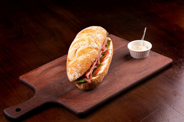 smoked carpaccio sandwich with arugula tomato and gruiere cheese on italian baguette on wooden...