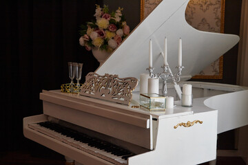 White grand piano standing in dark elegant classical interior
