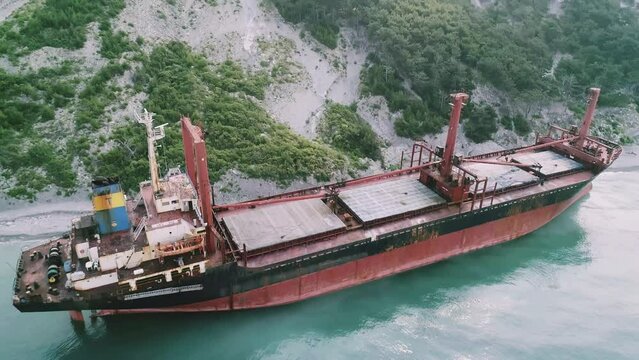 Aerial view of abandoned cargo ship. Bulk carrier ran aground after the storm. Dry cargo ship RIO stands ashore.