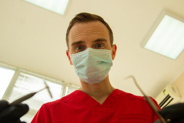 Fototapeta na wymiar doctor dentist in a red suit treats a man