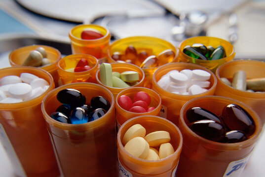 Close-up of an assortment of tablets and capsules in vials