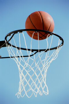 Close-up of a basketball on the edge of a hoop