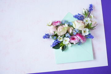  Spring bouquet of pink roses, daisies, muscari, forget me not flowers in an envelope, paper for congratulations text on a decorative background. Greeting card for Mother's Day, Womens Day, birthday, 