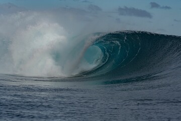 Beautiful shot of a huge blue wave in the ocean in Teahupoo village
