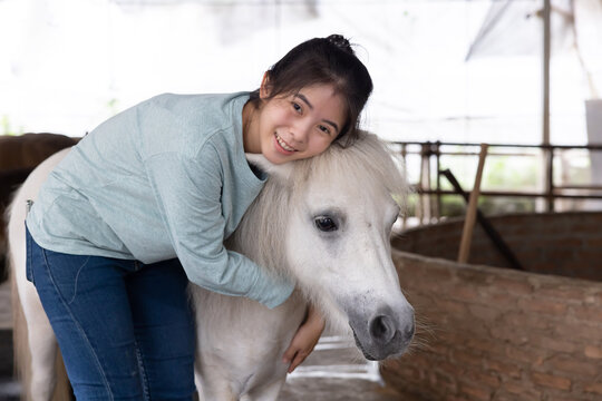 Asian Woman Hug Dwarf Horse in a Farm