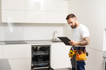 Technician or plumber repairing the dishwasher in a household
