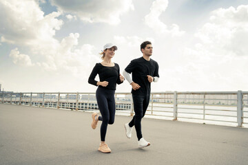 A woman and a man workout fitness running in sportswear and sneakers. Fitness bracelet on the arm...