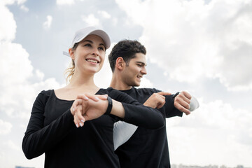 Fitness watch on your hand for pulse and calories. A woman and a man training fitness running in...