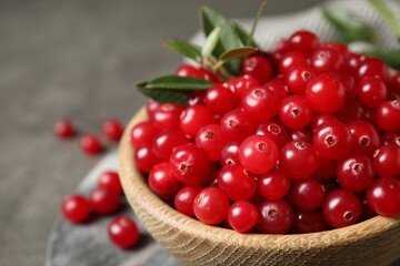 Bowl with tasty ripe cranberries on table, closeup