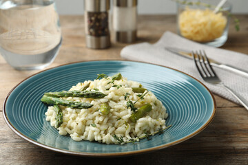 Delicious risotto with asparagus served on wooden table