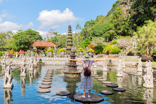 Tourist women wearing hat on holidays at Water Palace of Tirta Gangga in East Bali, Indonesia