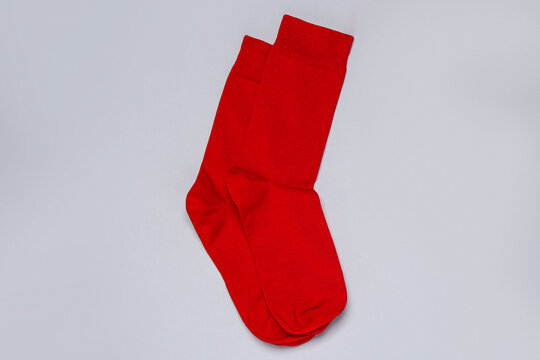 Pair of red socks on light grey background, flat lay