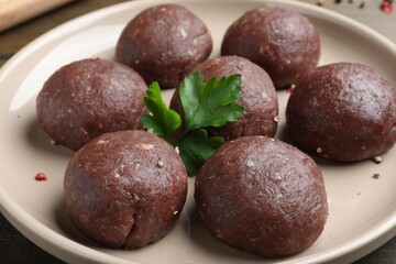 Many fresh raw meatballs on plate, closeup