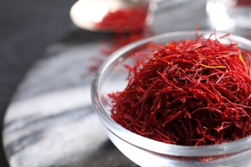 Dried saffron in glass bowl, closeup. Space for text
