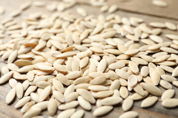 Raw cucumber seeds on wooden background, closeup. Vegetable planting