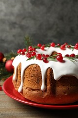 Traditional Christmas cake decorated with glaze, pomegranate seeds, cranberries and rosemary on...