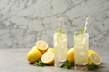 Natural lemonade with mint and fresh fruits on light grey table. Summer refreshing drink