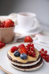 Crunchy rice cakes with peanut butter and sweet berries on plate