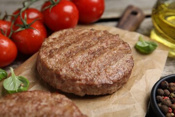 Tasty grilled hamburger patties with basil served on table, closeup